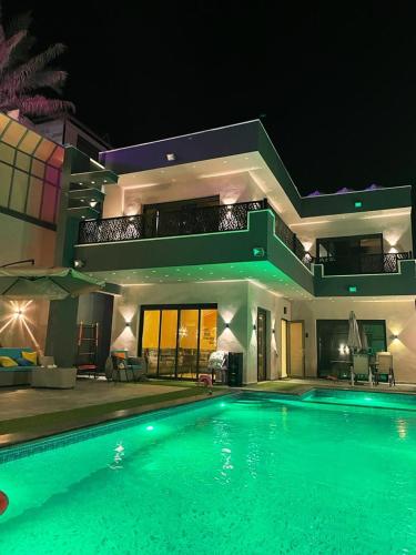 a large swimming pool in front of a house at night at Villa Jana chalet - Private Villa - Dead Sea - Jordan in Ash Shāghūr