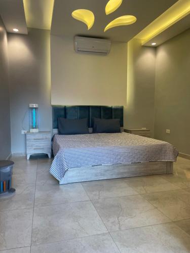 a bedroom with a large bed with a ceiling at Villa Jana chalet - Private Villa - Dead Sea - Jordan in Ash Shāghūr