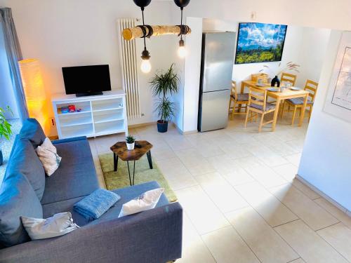 un soggiorno con divano blu e tavolo di Zwischen Wolfsburg, Tankumsee und Ilkerbruch - Apartment im Boldecker Land a Osloß