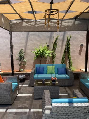 a patio with blue couches and plants in a tent at Villa Jana chalet - Private Villa - Dead Sea - Jordan in Ash Shāghūr