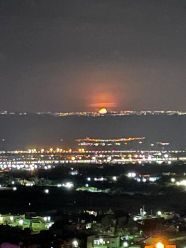a view of a city at night with the moon at Villa Jana chalet - Private Villa - Dead Sea - Jordan in Ash Shāghūr
