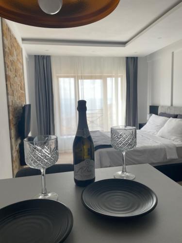 un tavolo con due bicchieri e una bottiglia di vino di Milmari N66 a Kopaonik