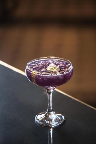 a purple drink in a martini glass on a table at Vinnhaus in Puerto Natales
