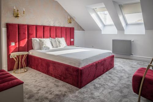 a bedroom with a large bed with a red headboard at Hotel Vila Central Boutique Satu Mare in Satu Mare