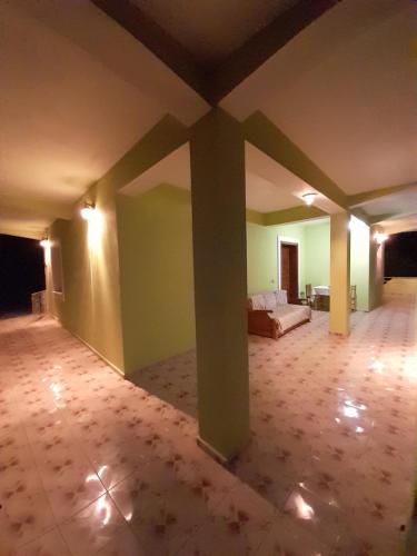 a large room with a couch and a bed in it at Cortina House Berat in Kuçovë