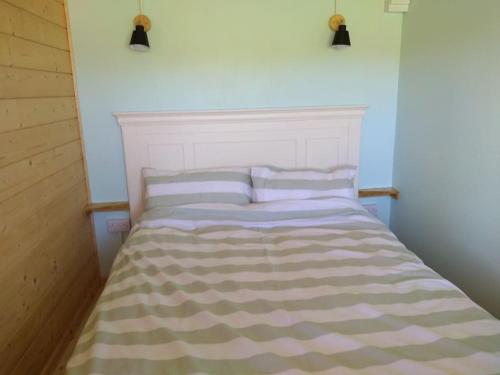 a bed in a room with two pillows on it at Cosy cabin for two in Truro
