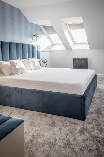 a large bed with a blue headboard in a room at Hotel Vila Central Boutique Satu Mare in Satu Mare