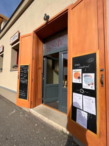 a store front with a door with signs in it at Apartmány v domečku in Hlinsko