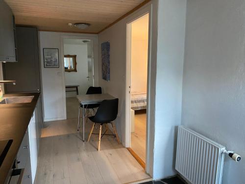 a small kitchen with a table and a room with a bed at Cosy apartment in Kvívík