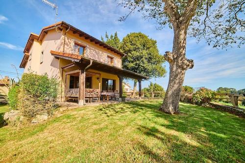 a house on a hill with a tree at Casa rural en plena naturaleza, playa, senderismo in Villahormes
