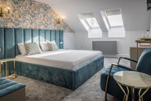 a bedroom with a large bed and a couch at Hotel Vila Central Boutique Satu Mare in Satu Mare