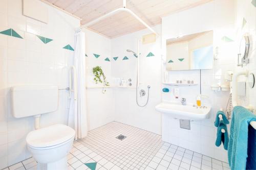 a white bathroom with a toilet and a sink at Familien- und Wellnesshotel "Viktoria" in Oberstdorf