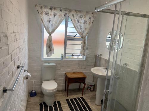 bagno con servizi igienici, lavandino e finestra di Strandfontein holiday house a Strandfontein