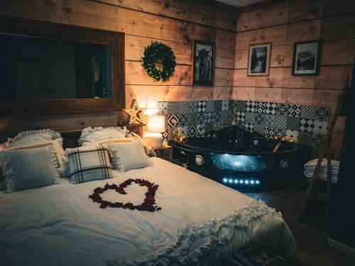 a bedroom with a large bed and a tub at Le chalet montagne insolite avec spa et écran cinéma ! in Évreux