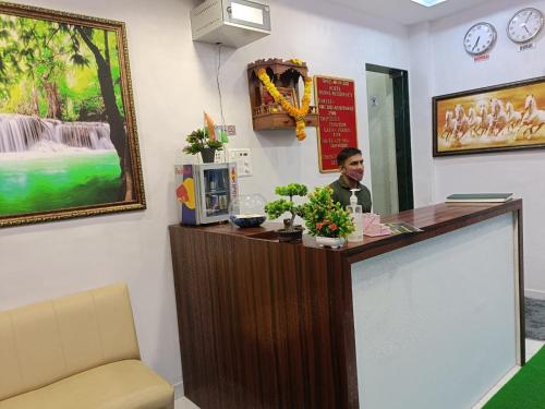 a man sitting at a cash register in a room at Hotel Royal Residency in Navi Mumbai