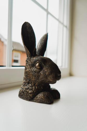 a statue of a rabbit sitting on a window sill at Corner Cottage - character, charm, great location. in Ringwood