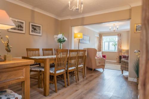 a dining room and living room with a table and chairs at Corner Cottage - character, charm, great location. in Ringwood