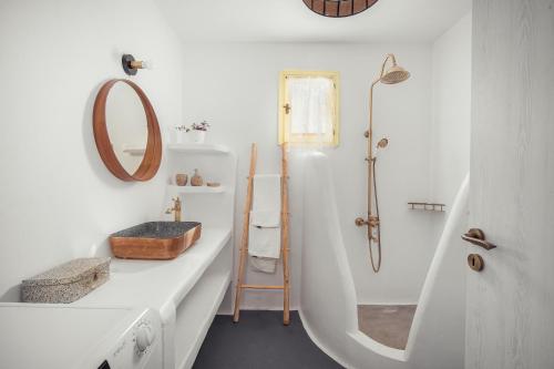 a white bathroom with a sink and a shower at Livas Residence in Megálon Khoríon