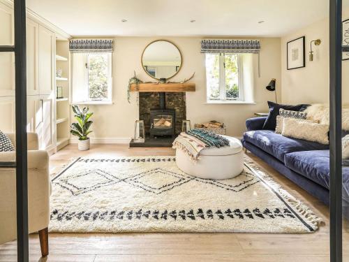 uma sala de estar com um sofá e uma lareira em Grove Cottage em Salperton