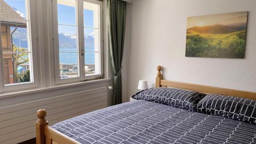 1 dormitorio con cama y ventana grande en Holiday Apartments Falke, en Brienz