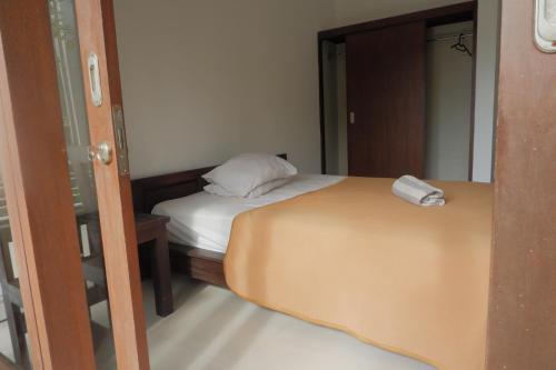 a small bedroom with a bed and a mirror at Baik Baik Homestay in Uluwatu