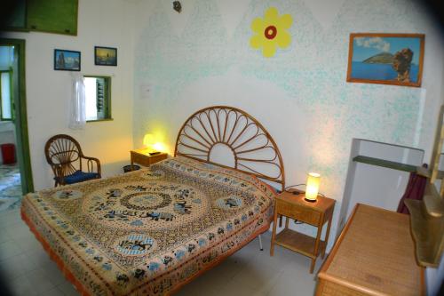 ein Schlafzimmer mit einem Bett mit einer Blume an der Wand in der Unterkunft Holiday Home Case Blu in Lipari