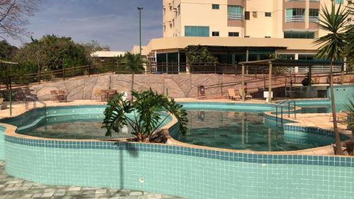 a swimming pool in front of a building at Apartamento 502 para 5 pessoas Caldas Novas Thermas do Bosque in Caldas Novas