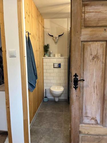 a bathroom with a toilet and a cow head on the wall at Kresy Wschodnie in Okszów