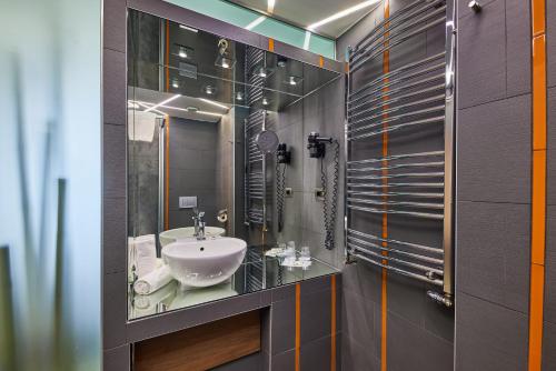 ein Bad mit einem Waschbecken und einem Spiegel in der Unterkunft Vital Hotel Nautis in Gárdony