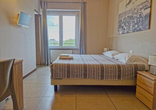 a bedroom with a bed and a large window at B&B Viale San Pietro in Sassari