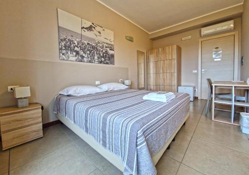 a bedroom with a bed with a blue and white blanket at B&B Viale San Pietro in Sassari