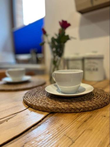 a cup and a plate on a wooden table at Kresy Wschodnie in Okszów