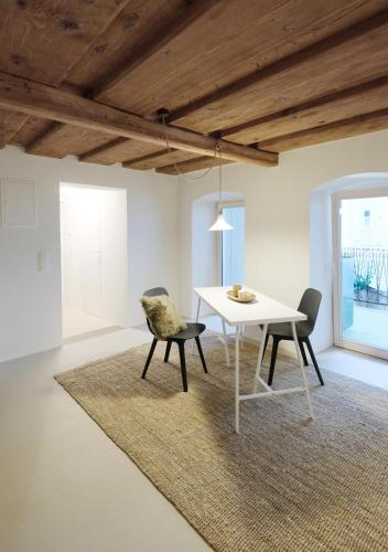 a dining room with a white table and chairs at HERZIGE WOHNUNG IN ALTEM GEMÄUER in Linz
