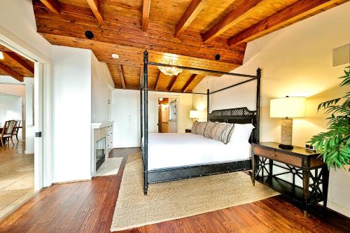 a bedroom with a canopy bed and a wooden ceiling at Cliff Dr View in Laguna Beach