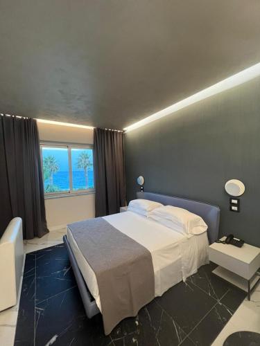 a bedroom with a large bed and a window at Club Hotel Kennedy in Roccella Ionica