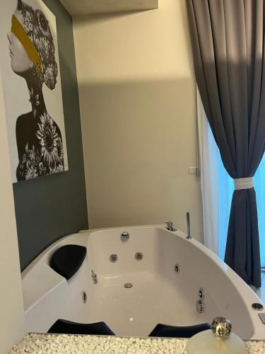 a bath tub in a bathroom with a painting on the wall at Club Hotel Kennedy in Roccella Ionica