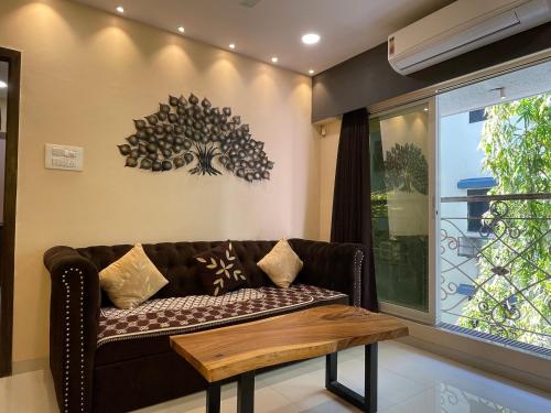 a living room with a couch and a table at OSI Apartments Bandra West in Mumbai