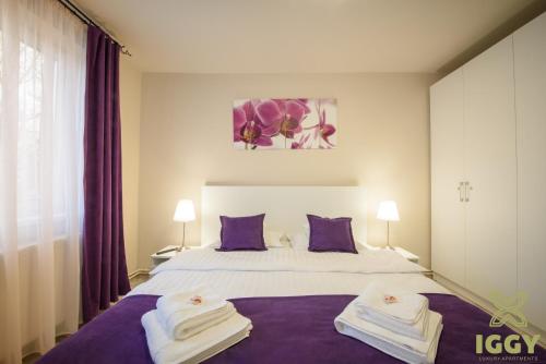 una camera da letto con un grande letto con asciugamani di Iggy Luxury Apartment a Hunedoara