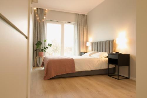Un dormitorio con una cama grande y una ventana en Hygge Malta - NOWY apartament, en Poznan