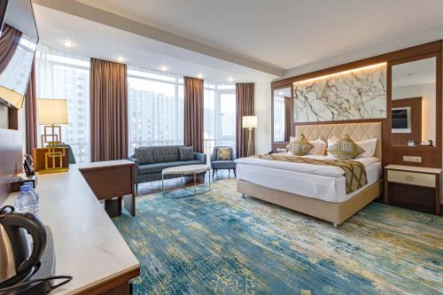 a hotel room with a bed and a living room at Best Western Plus Astana Hotel in Astana