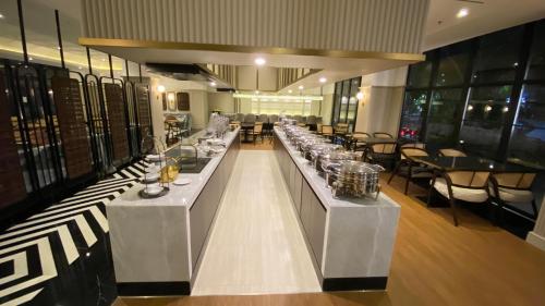 a restaurant with a long counter with glasses on it at Maia Hotel Jakarta in Jakarta