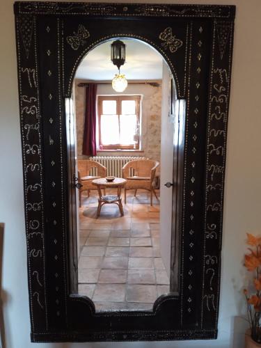 an ornate mirror reflecting a living room with a table at chez Karine in Ceyzérieu