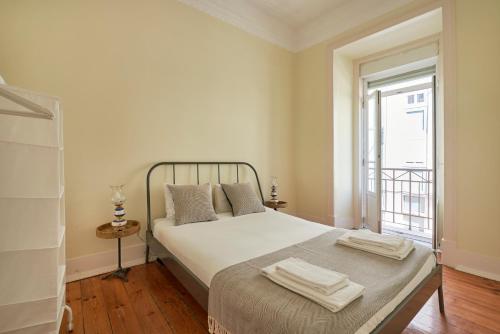 una camera da letto con un letto e due asciugamani di Renovated Spacious Baixa Apartment, By TimeCooler a Lisbona