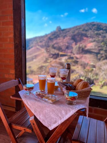a table with a basket of bread and glasses of beer at Chalés Luar da Mantiqueira in Sapucaí-Mirim