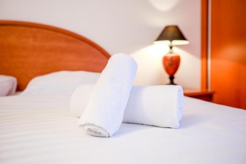 two rolls of towels on a bed with a lamp at Hotel Barborka in Přední Výtoň