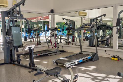 a gym with several tread machines in front of a mirror at Blue Fish Hotel in Konaklı