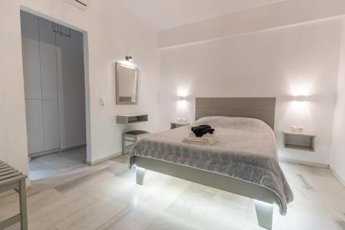 Habitación blanca con cama y espejo en Alpha Studios (Adults Only) en Naxos