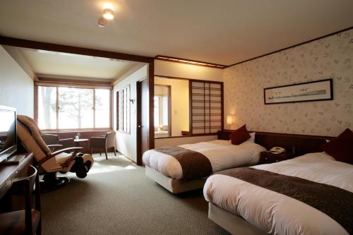 Shikotsuko Onsen Lake Side Villa SUIMEIKAKU-Adult Only في تشيتوسي: غرفه فندقيه سريرين وتلفزيون