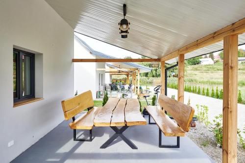 drewniany stół i ławki na patio w obiekcie Zatoka Perska - dom GREK nad jeziorem Tarnobrzeskim w Tarnobrzegu