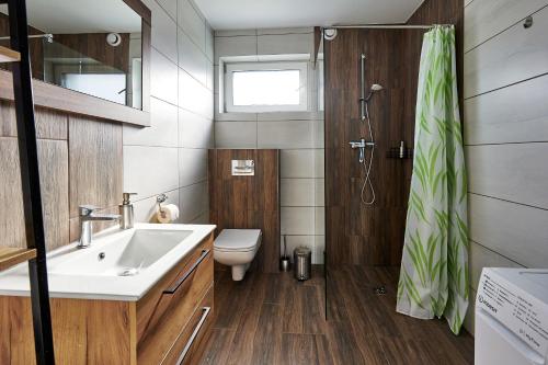 a bathroom with a sink and a toilet and a shower at Zatoka Perska - dom GREK nad jeziorem Tarnobrzeskim in Tarnobrzeg